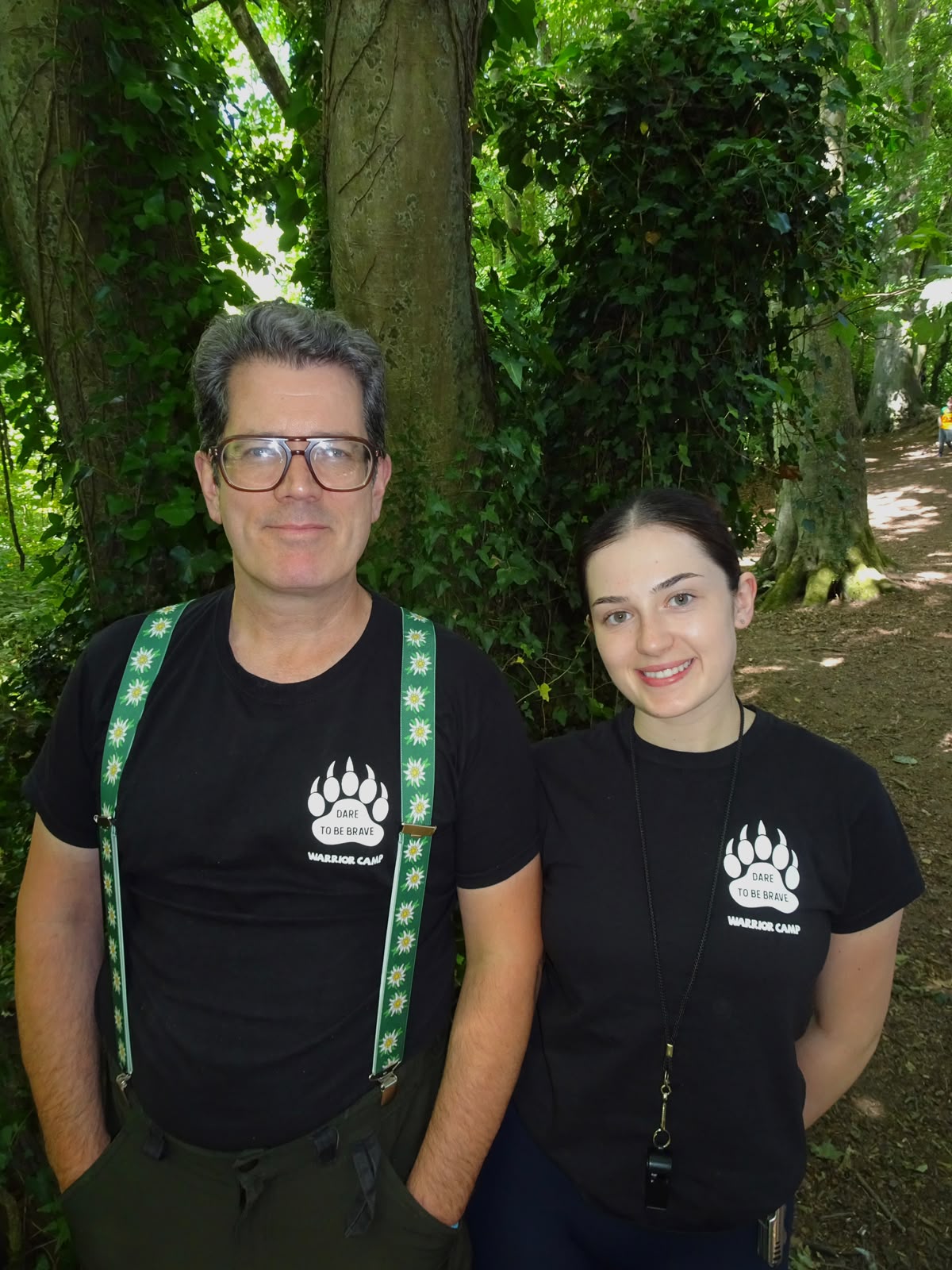 Founder Oliver O'Donoghue and leader Mia smiling in WarriorCamp T-shirts in the Beaulieu woods